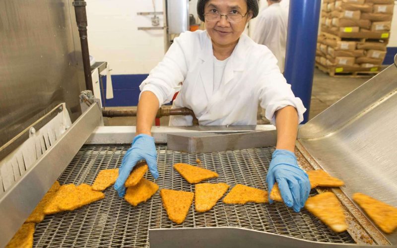 university chef frying fish in a school cafeteria