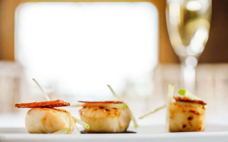 A photo of plated delicious scallops.