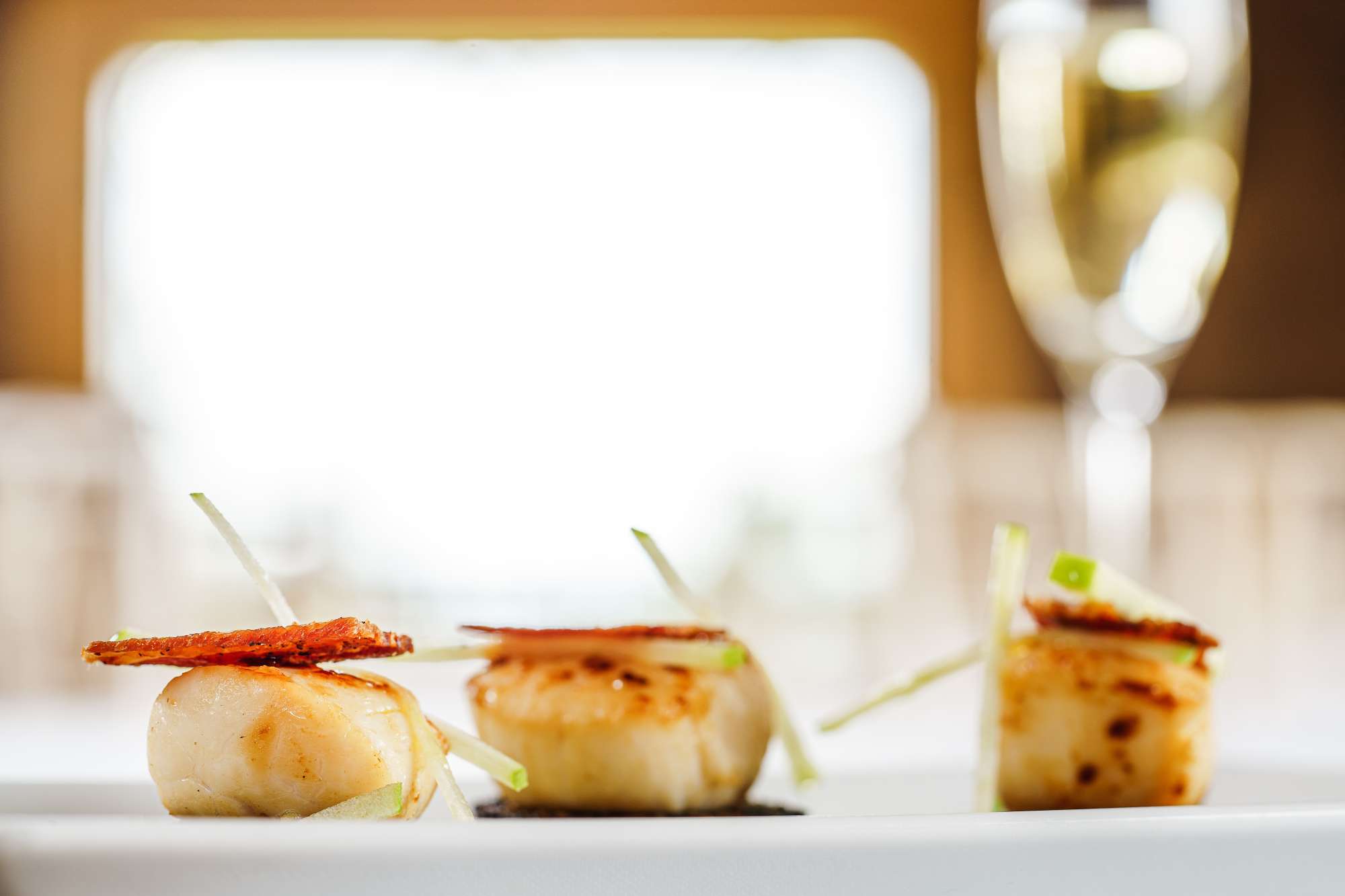 A photo of plated delicious scallops.